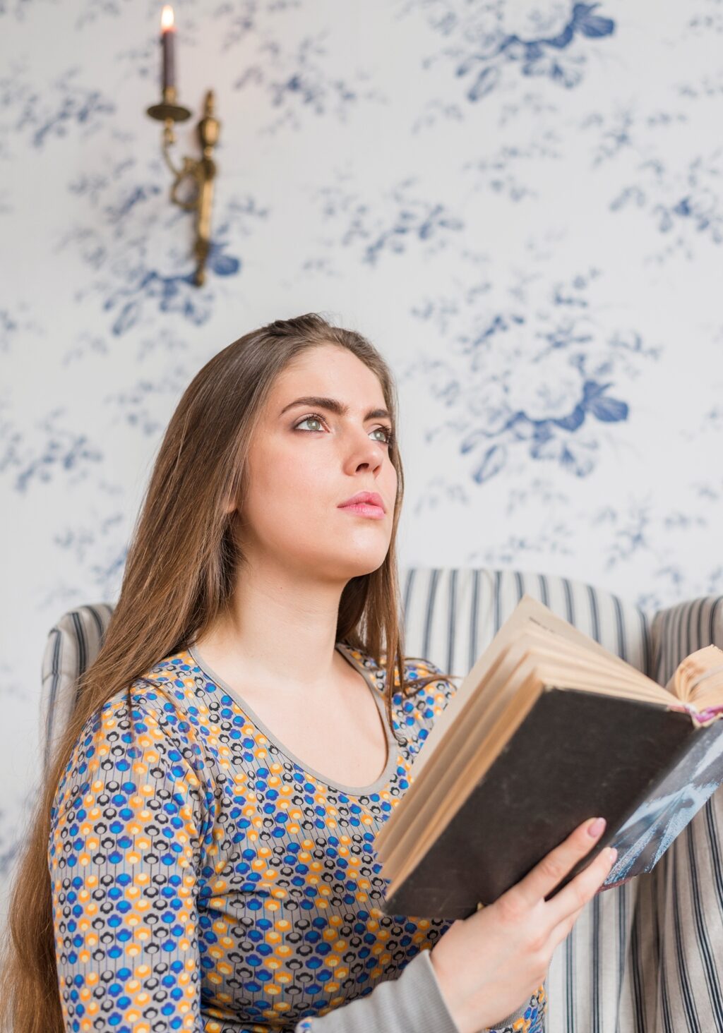 contemplated-young-woman-holding-book-hand-looking-up resized